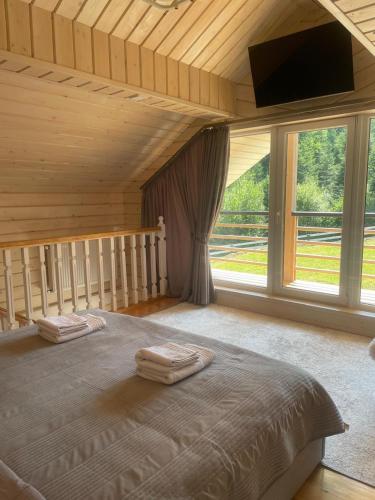 a bedroom with a large bed with a large window at InMonteHouse in Migovo