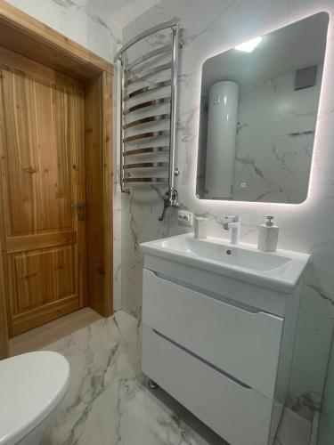 a white bathroom with a sink and a mirror at InMonteHouse in Migovo