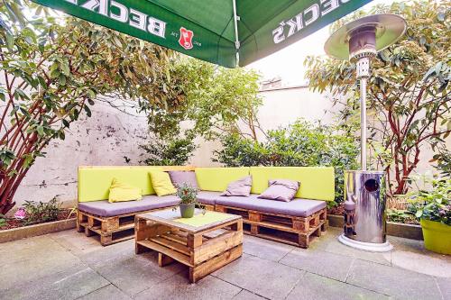 a yellow couch with pillows sitting on a patio at DJH-Gästehaus Bermuda3Eck in Bochum