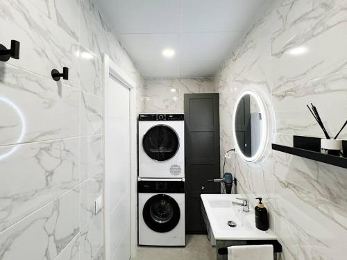 a bathroom with a washer and dryer next to a sink at Studio Alborán in Málaga