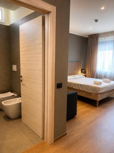 a room with a bed and a bathroom with a door at Residenza Ricci in Azzano San Paolo