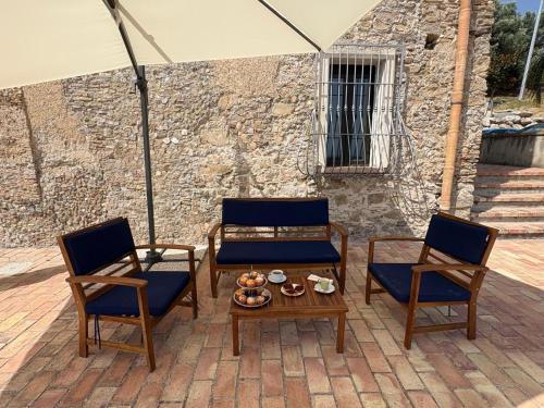 a patio with two chairs and a table and an umbrella at Casolare La Mirabella 