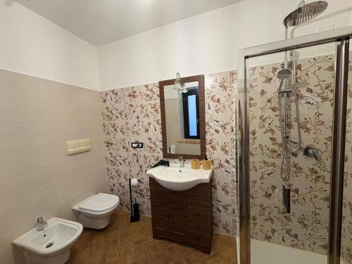 a bathroom with a toilet and a sink and a shower at Casolare La Mirabella 