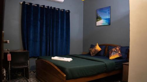 a bedroom with a bed with a blue curtain at FabHotels Divo in Chennai