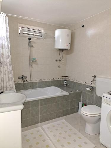 a bathroom with a tub and a toilet and a sink at Villa Senka in Nečujam