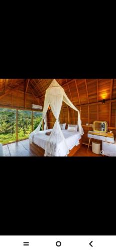 a bedroom with a bed with a mosquito net at Suwehan Blue Ocean Cliff in Semarapura