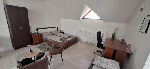 a bedroom with a bed and a desk and a table at STUDIO Apartman in Gheorgheni