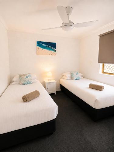 two beds in a room with white walls at Geraldton's Ocean West Holiday Units & Short Stay Accommodation in Geraldton