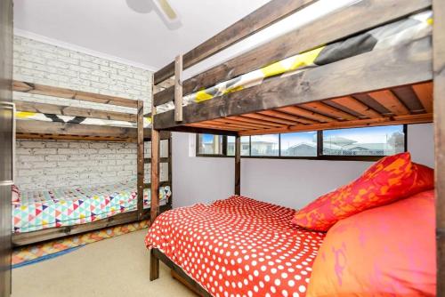 a bedroom with two bunk beds and a red bed at NR 4 Cove Apartment Carrickalinga in Carrickalinga