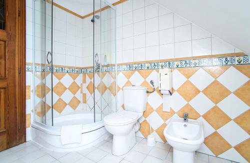 a bathroom with a toilet and a sink and a shower at Gastland M1 Hotel & Conference Center in Páty