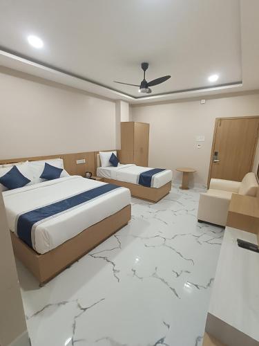 two beds in a room with a marble floor at Hotel Shiny Grand in Guwahati