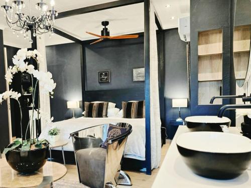 a bedroom with a bed and a table and a tub at Maison PJURE Boutique Hotel & Spa , Adults Only in Montagu