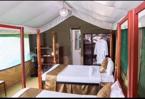 a bedroom with a bed with a canopy and a robe at La Maison Mara in Ololaimutiek
