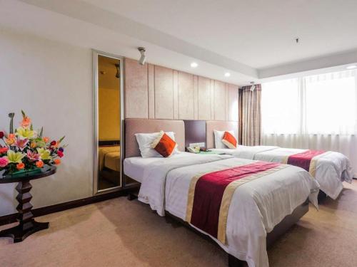 a hotel room with two beds and a window at New World Hotel in Guangzhou