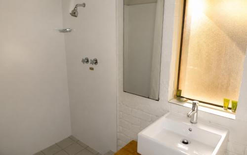 a white bathroom with a sink and a shower at Geraldton's Ocean West Holiday Units & Short Stay Accommodation in Geraldton