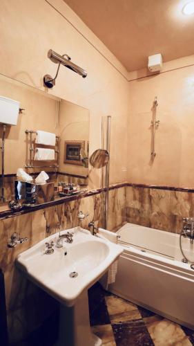 a bathroom with a sink and a bath tub at Residenza Palazzo Visdomini in Pietrasanta