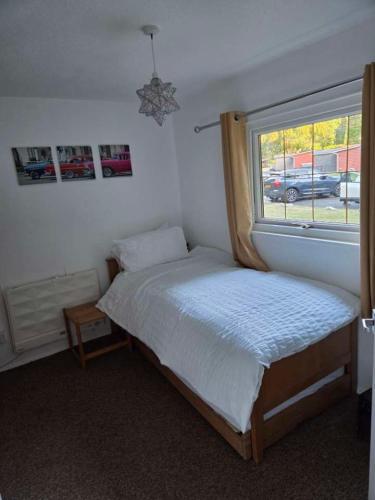 a bedroom with a bed and a window at Waters Edge Lodge in Caeathro