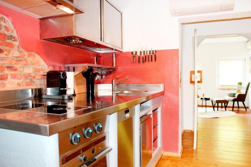 a kitchen with a sink and a stove top oven at Rost Apartments - Design Ferienhaus mit Kamin und Hängematte in Laufen