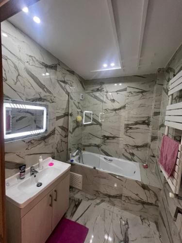a bathroom with a tub and a sink and a bath tub at luxury apartment in Annaba