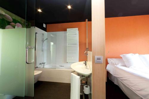 a bathroom with a bed and a sink and a shower at Grupo Izarbe, HOTEL ELLAURI in Zeanuri
