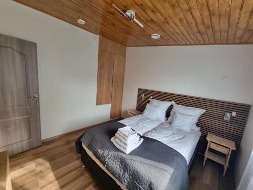 a bedroom with a large bed with a wooden ceiling at Karlskovhuset in Give