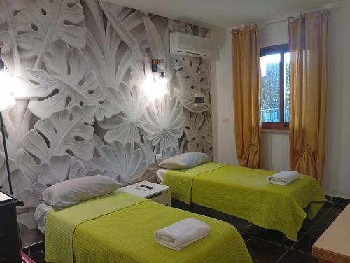 two beds in a room with green sheets at Lillo Home in Isernia