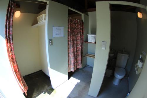 a small bathroom with a toilet and a window at PavilionSurf&Lodge in Shishikui