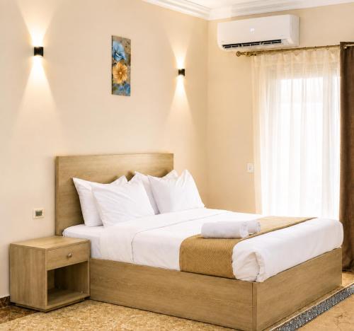 a bedroom with a large bed and a window at Roadhouse New Cairo Residence in Cairo