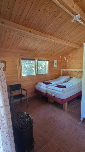 a bedroom with two beds in a wooden cabin at Podere Lama in Castelnuovo di Val di Cecina