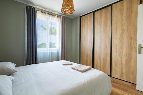 a bedroom with a large white bed and a window at Le Beauregard - Piscine in Beauregard-Baret