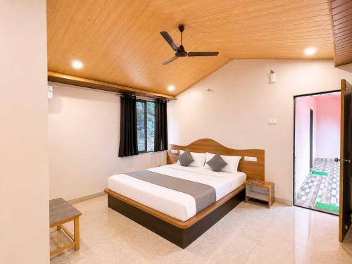 a bedroom with a bed and a ceiling fan at Collection O Parsi Point Mahabaleshwar Formerly Jungle Eye in Mahabaleshwar
