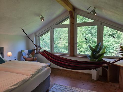 a hammock in a bedroom with windows at Rost Apartments - Design Ferienhaus mit Kamin und Hängematte in Laufen
