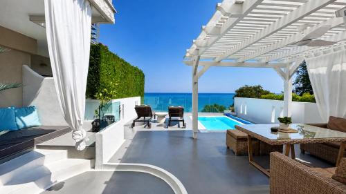 an outdoor patio with a view of the ocean at Panorama Suites & Spa - Adults Only in Stomio