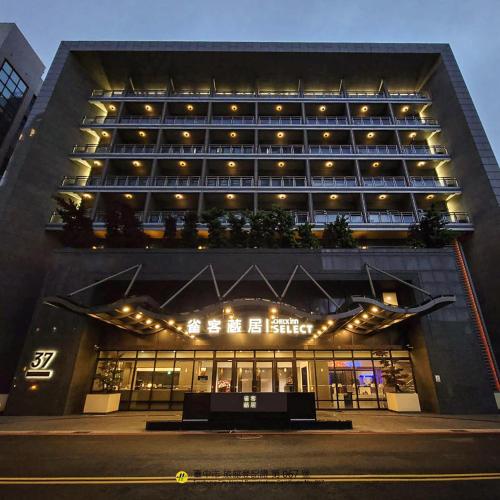 ein großes Gebäude mit einer Bank davor in der Unterkunft CHECK inn SELECT Taichung Dadun in Taichung