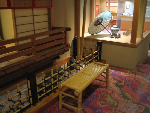 a room with a bench and a fan in a church at Yudanaka Tawaraya Ryokan in Yamanouchi