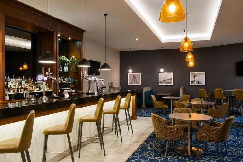 a restaurant with tables and chairs and a bar at Leonardo Hotel Middlesbrough in Middlesbrough