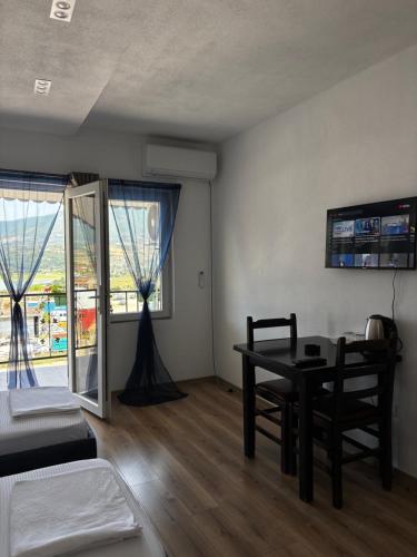a room with a table and a table and chairs at ARBI GUEST House in Kukës