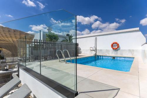 a swimming pool in a house with a glass facade at Intelier Casa de Indias in Seville
