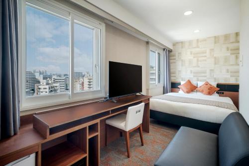 a bedroom with a desk and a bed and a desk with a computer at HOTEL MYSTAYS Nagoya Sakae -Renewed in September 2026 All Guest Rooms & Breakfast in Nagoya