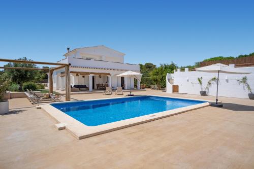 a swimming pool in front of a house at VILLA JESSELLA in Punta Prima