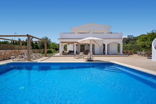 a swimming pool in front of a villa at VILLA JESSELLA in Punta Prima