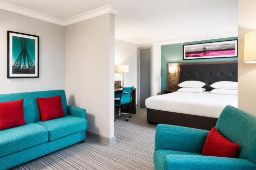 a hotel room with a bed and two chairs at Leonardo Hotel Middlesbrough in Middlesbrough