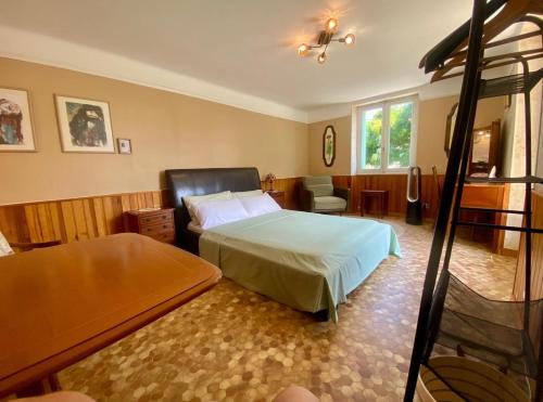 a bedroom with a bed and a chair at Chez Chagall cozy studio in Sarlat-la-Canéda
