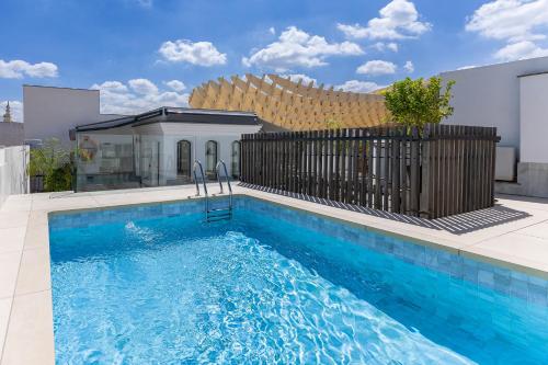 a swimming pool in front of a house at Intelier Casa de Indias in Seville