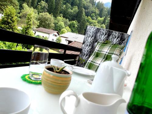 a table with a cup of coffee and a vase at Hofwiese in Hohenschwangau