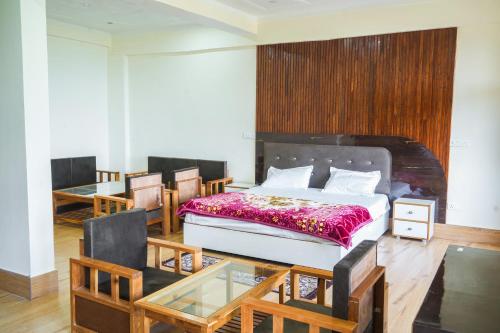 a bedroom with a bed and a glass table at The Kalindi's Resort, Almora in Almora