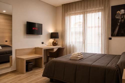 a bedroom with a bed and a desk and a window at ALMA ROOM in Santa Maria Capua Vetere