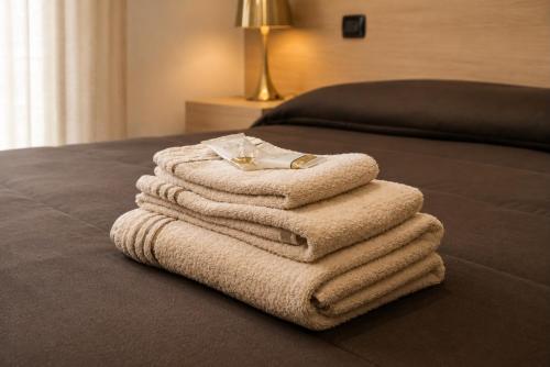 a pile of towels sitting on top of a bed at ALMA ROOM in Santa Maria Capua Vetere