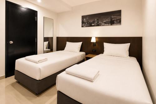 two beds in a hotel room with sidx sidx sidx sidx sidx at The Blocks Hostel Sukhumvit 10 in Bangkok