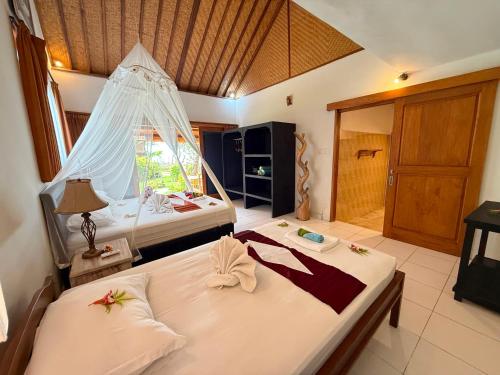 a bedroom with two beds with towels on them at Alam Mimpi Bali in Tejakula